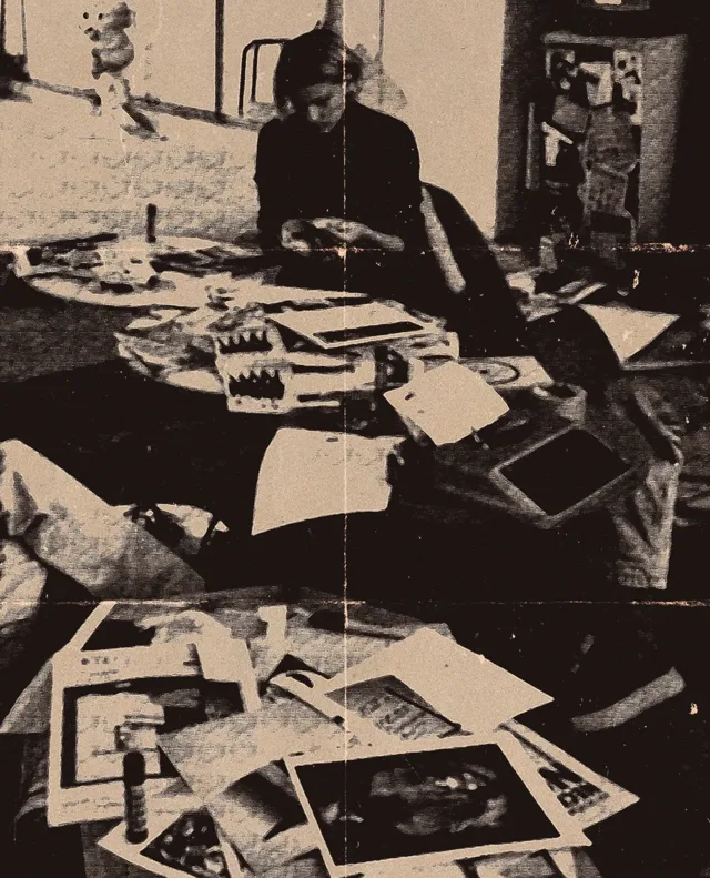 Collaging at a table covered in cut paper
